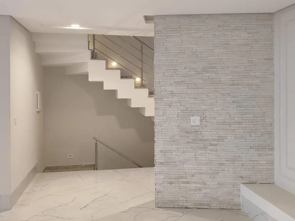 Escada com parede revestida e piso de mármore claro